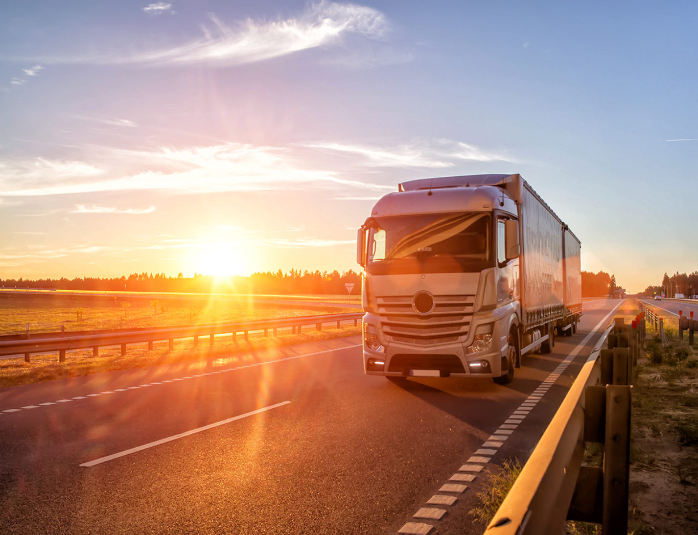 Modern wagon truck transports cargo against the backdrop of a sunset. The concept of truck drivers in the field of freight and logistics, copy space, hindcarriage