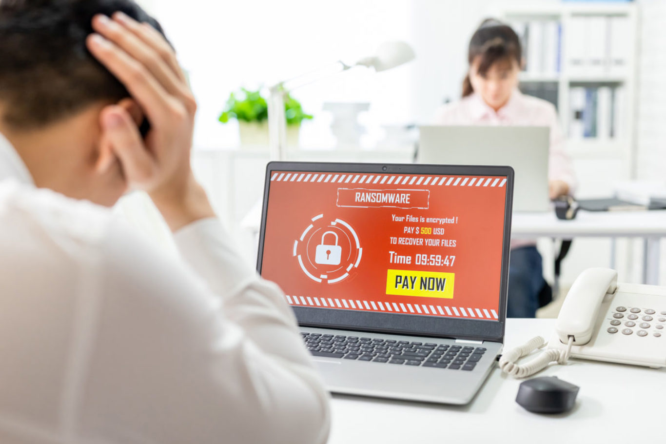 asian worried young businessman looking at laptop computer with ransomware attack words on the screen in office