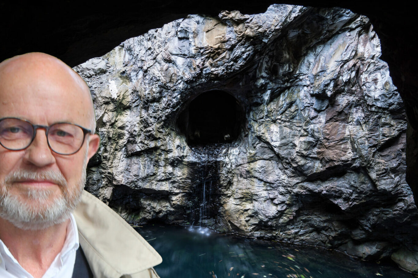 Shaft and drift from the inside an old closed down mine with blue water and sunshine entering from the roof