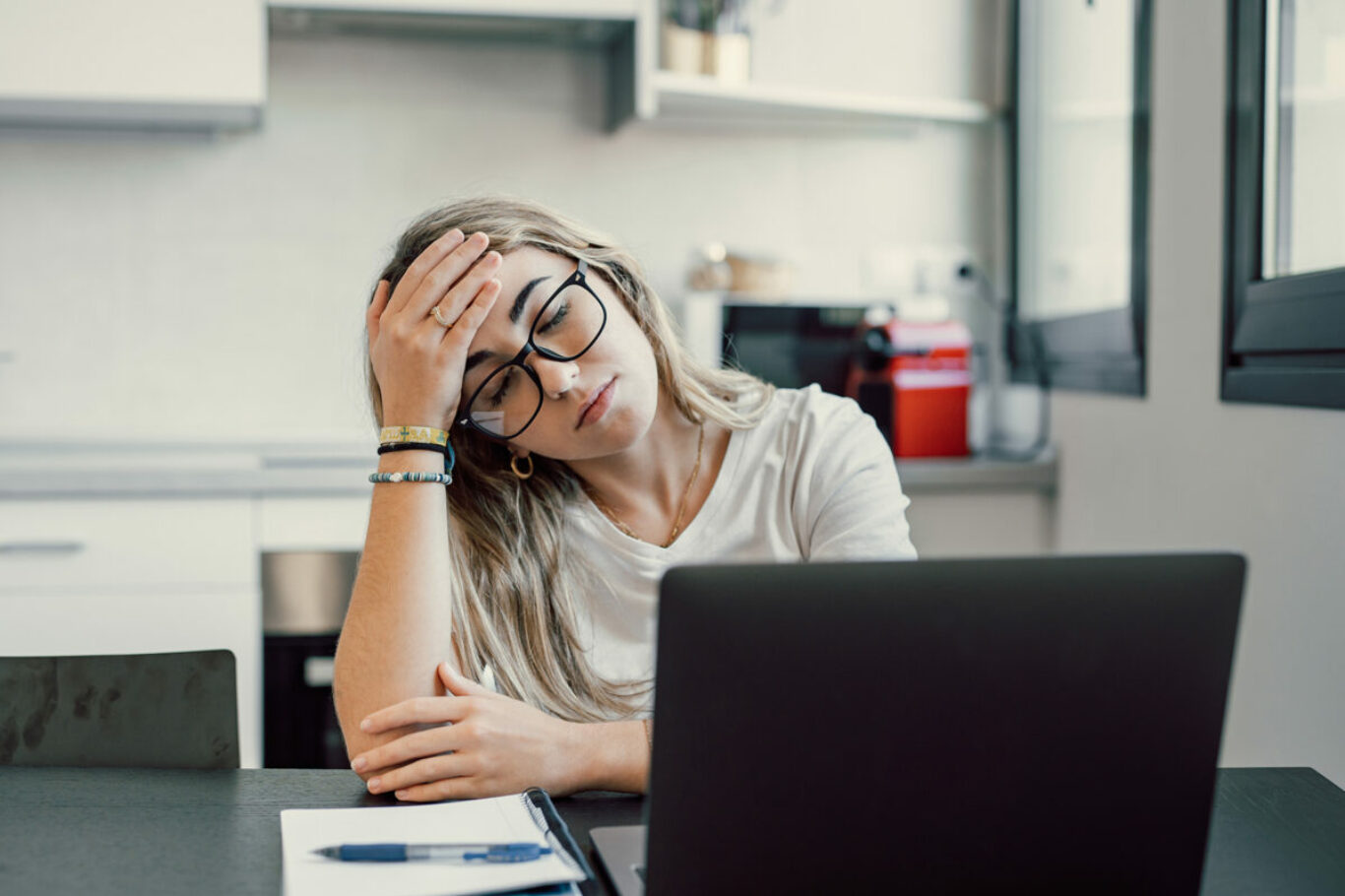 Stressed tired woman in pain having strong terrible headache attack after computer laptop study, fatigued exhausted girl suffering from chronic migraine massaging temples to relieve head ache tension