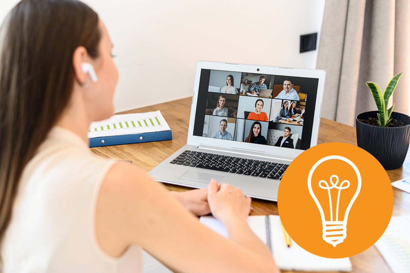 Virtual video conference, online meeting with a many employees together. A young woman is communicating via video call with coworkers, a several webcam shot of people on the laptop screen