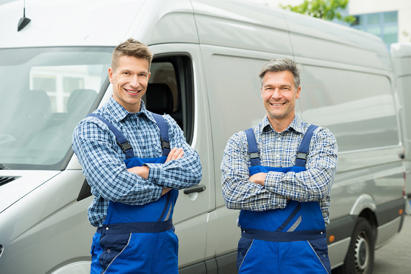 Two Happy Repairmen In Overall With Arms Crossed In Front Of Van
