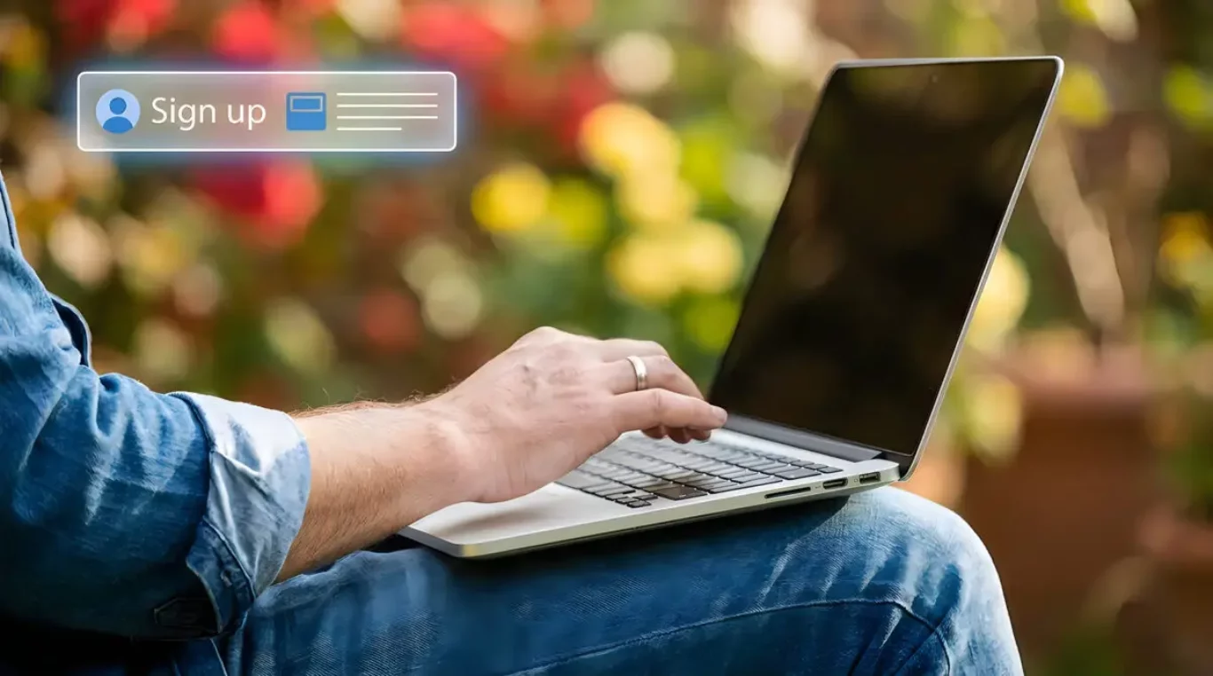 Person using laptop in outdoor setting with blurred background f